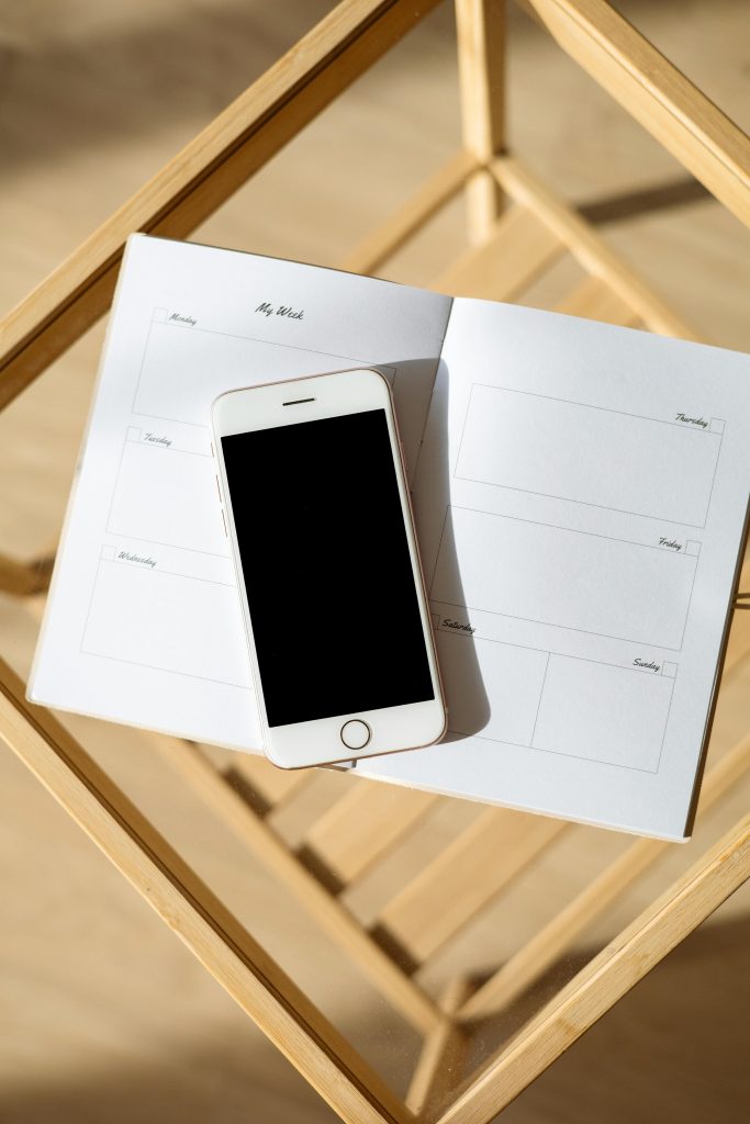 Phone and piece of paper on a table, symbolizing contact for dog training services at Dogology University