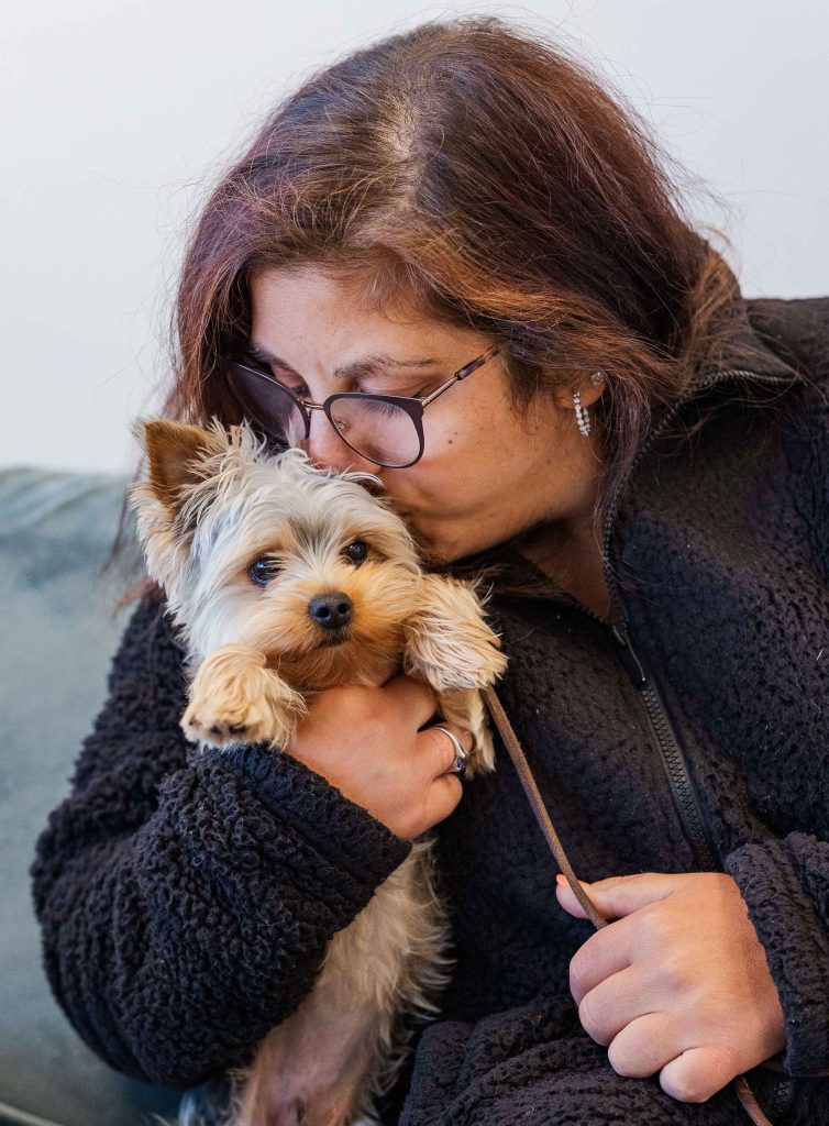 Woman kissing her Yorkie during a Dogology University evaluation session, highlighting their bond