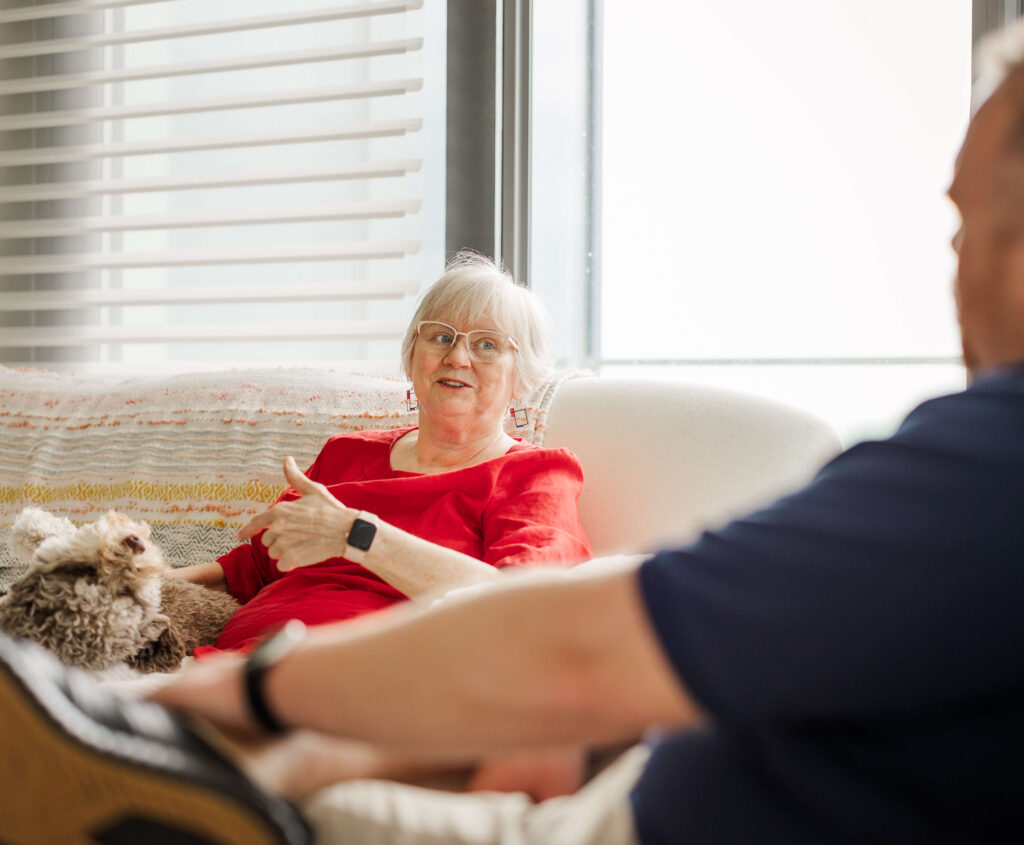 Dog owner talking with Dogology University trainer during an in-home training visit in Grand Haven Michigan